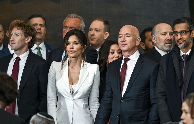 FILE – From right: Sundar Pichai of Google; Jeff Bezos of Amazon with his fiancŽe, Lauren Sanchez; and Mark Zuckerberg of Meta stand in front of cabinet nominees at President Donald Trump’s inauguration in Washington, Jan. 20, 2025. As tech titans have embraced President Trump and muffled internal dissent at their companies, their mostly left-leaning employees have objected with subtle acts of defiance. (Kenny Holston/The New York Times)