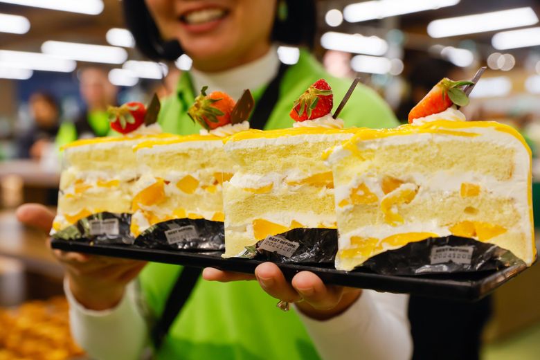 T&T Supermarket CEO Tina Lee shows off her deli’s fan-favorite fresh mango cake on Dec. 4, 2024, in Bellevue. That sprawling Bellevue T&T location is the brand’s first in the United States. The British Columbia chain plans to open another outpost in 2025 in Lynnwood. (Jennifer Buchanan / The Seattle Times)