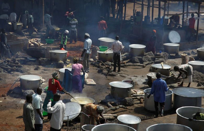 FILE -Refugees prepare food including maize porridge donated by USAID and known locally as posho, during the visit of U.N., Aug. 29, 2016. (AP Photo/Stephen Wandera, File) WX501 WX501