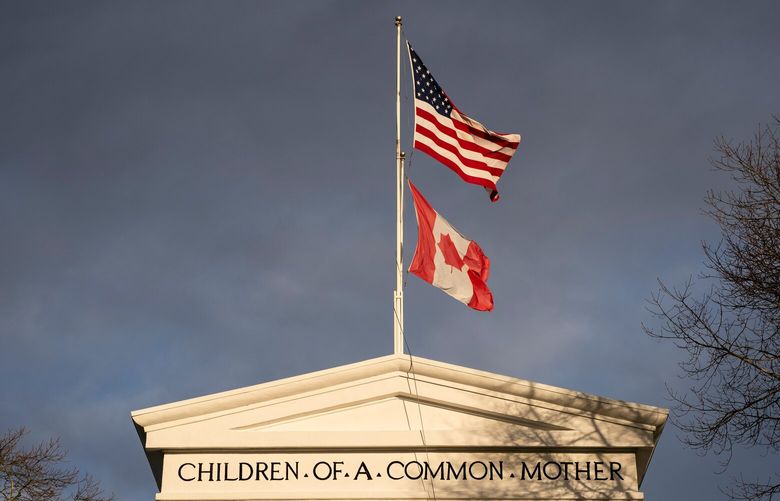 Flags from Canada and the US fly atop the Peace Arch at the Peace Arch Border Crossing in Blaine, Washington, US, on Wednesday, Dec. 18, 2024. Canada’s trade surplus with the US helped the northern nation avoid a deeper overall deficit, underscoring the importance of its biggest trading partner as President-elect Donald Trump threatens crippling tariffs. Photographer: David Ryder/Bloomberg