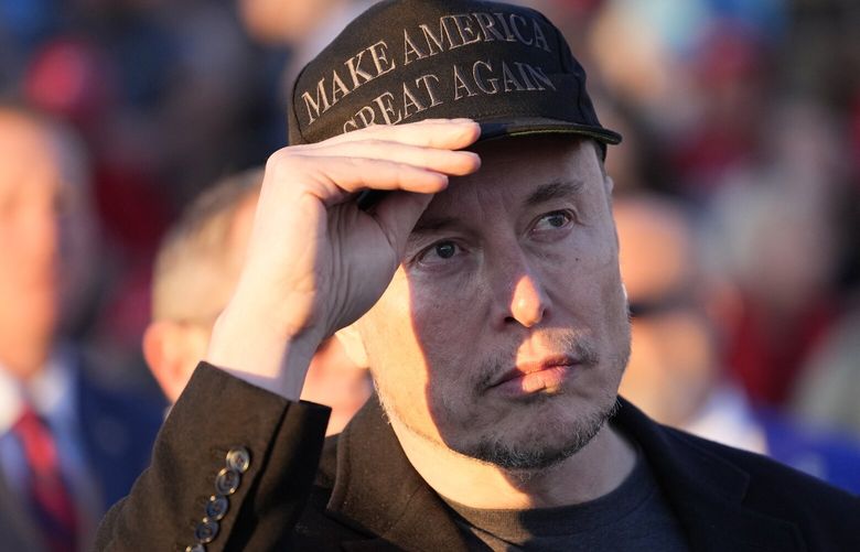 FILE – Elon Musk listens as Republican presidential nominee former President Donald Trump speaks at a campaign event at the Butler Farm Show on Oct. 5, 2024, in Butler, Pa. (AP Photo/Alex Brandon, File) NYRL412 NYRL412