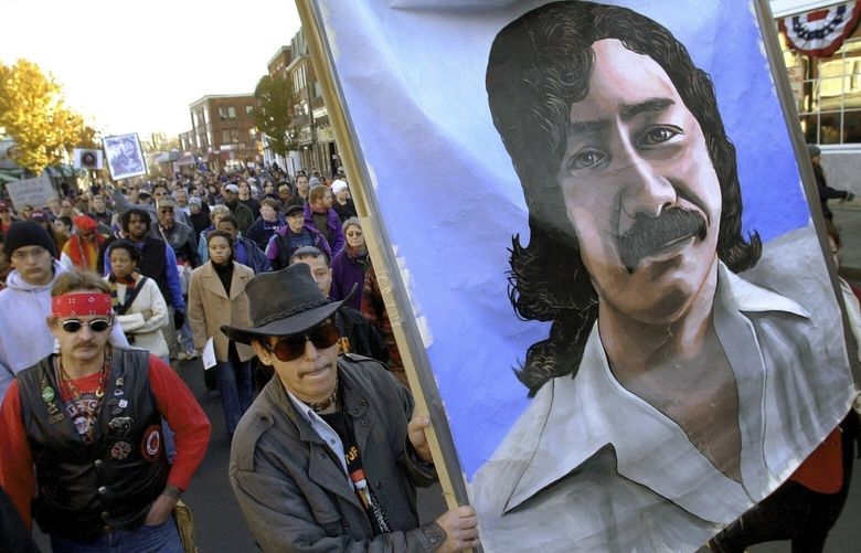 FILE – Marchers carry a large painting of jailed American Indian Leonard Peltier during a march on the National Day of Mourning in Plymouth, Mass., Nov. 22, 2001. (AP Photo/Steven Senne, File) XLM110 XLM110