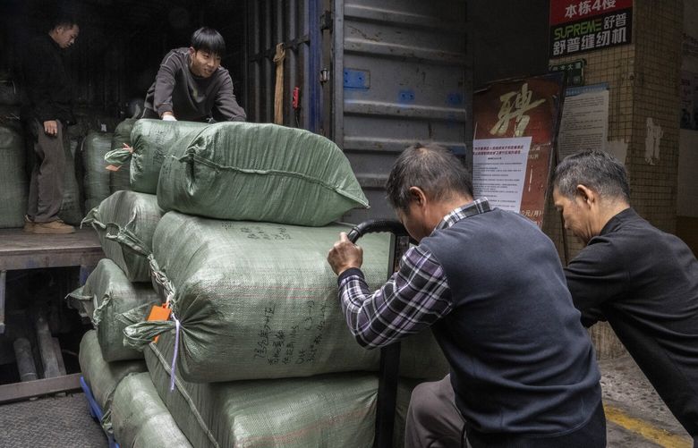 Workers load packs of new clothes on a truck at a garment industrial park in Guangzhou, China, Feb. 12, 2025. The increasing demand for low-cost shipments from China is driven by the rise of e-commerce sellers around the world. (Gilles Sabrié/The New York Times) XNYT0278 XNYT0278