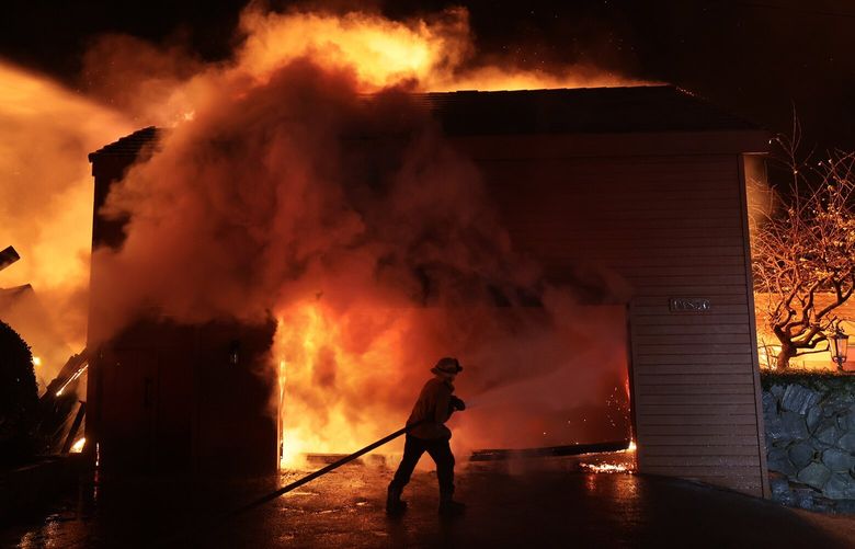 A firefighter battles a house fire along PCH as the Palisades Fire burns in Malibu, California on Wednesday, Jan. 8, 2025. (Wally Skalij/Los Angeles Times/TNS) 134924241W 134924241W