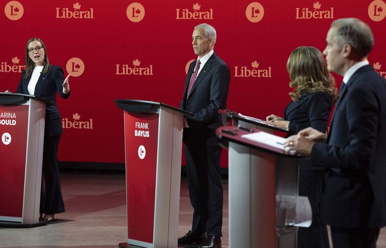Liberal Party of Canada leadership candidate Karina Gould, left, speaks as Frank Baylis, Chrystia Freeland and Mark Carney look on during the English-language Liberal Leadership debate in Montreal on Tuesday, Feb. 25, 2025. (Christinne Muschi/The Canadian Press via AP) CMU106 CMU106