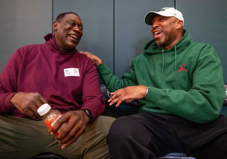Former Sonics Shawn Kemp, left, and Vin Baker catch up  before the start of a youth basketball clinic last month. (Ken Lambert / The Seattle Times)