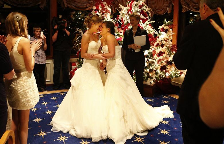 Mary Davidson, 27, left, and Monica Rozgay, 29, smile after saying ‘I do’ at their midnight wedding at The Seattle Yacht Club early Sunday Dec. 9, 2012. Rozgay and Davidson, of Seattle, are one of the first couples to wed following the passage of Referendum 74, which approved a bill legalizing same-sex marriage in the state of Washington.
