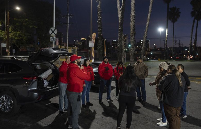 Volunteers working with Union del Barrio, an organization advocating for immigrant rights, gather in a parking lot before heading out to search for ICE activity in Los Angeles Thursday, Feb. 27, 2025. (AP Photo/Jae C. Hong) CAJH104 CAJH104