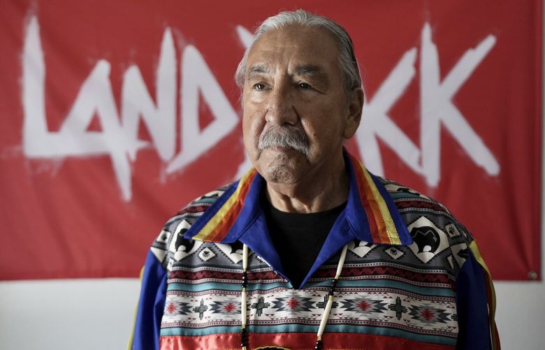 Leonard Peltier stands for a portrait in front of a Land Back movement flag in Belcourt, N.D, on Tuesday, Feb. 25, 2025. (AP Photo/Mark Vancleave) NYOTK NYOTK