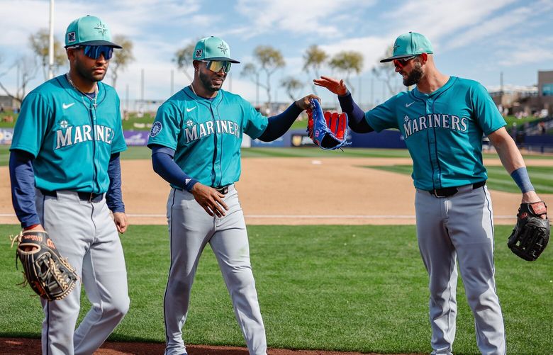 Mitch Haniger, right, congratulates centerfielder Victor Robles on the catch of the Jake Bauers fly that gets the Mariners out of the inning.  The Seattle Mariners played the Milwaukee Brewers in Spring Training baseball Monday, Feb. 24, 2025 at American Family Fields, in Phoenix, AZ. 229402