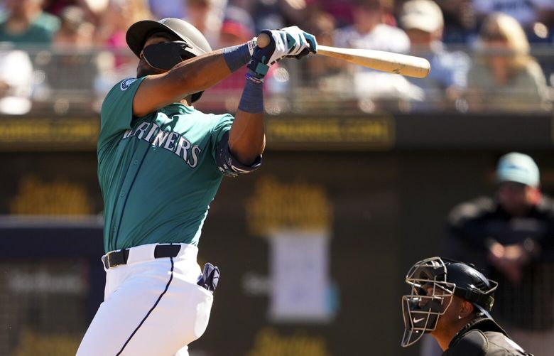 Seattle Mariners’ Julio Rodriguez follows through on a sacrifice fly to score Ben Williamson in the second inning against the Arizona Diamondbacks during a spring training baseball game Sunday, Feb. 23, 2025, in Peoria, Ariz. (AP Photo/Lindsey Wasson) AZLW734 AZLW734