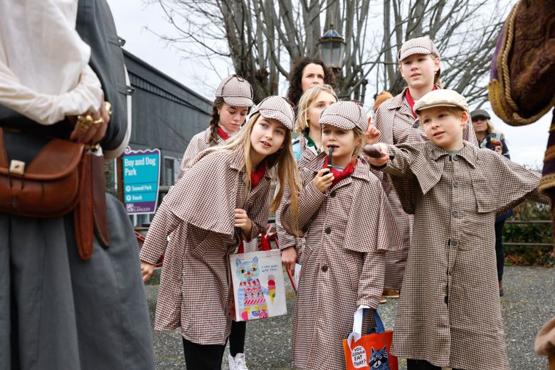 The 40th anniversary of Langley Mystery Weekend on Feb. 22 brought a group of Teeny Detectives from Seattle, with Catherine Shepherd (back middle) chaperoning. From left to right, bottom row: Ellerie Lampe, 10; Elijah Carlile, 6; Julius Hanseroth, 8. Back row: Sawyer Lampe, 13, Evangeline Carlile, 10, Josephine Hanseroth, 12 asking pirates Voldar Hoarabull played by Matt Hoar, left, and Blacky Beardsley, right, played by Bexar O’Riley, about their knives. (Karen Ducey / The Seattle Times)