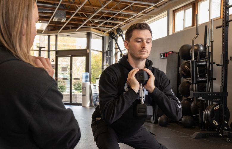 A Seattle Strength and Performance coach leads a gym member through a personalized workout with a kettlebell. Seattle Strength and Performance is one of more than 30 gyms around the Seattle area participating in Seattle Fitness Week from March 6-15.