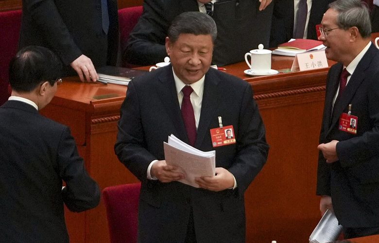 Chinese President Xi Jinping, center, and his Premier Li Qiang, left, prepare to leave the hall after attending the opening session of the National People’s Congress held at the Great Hall of the People in Beijing, Wednesday, March 5, 2025. (AP Photo/Andy Wong) XAW107 XAW107