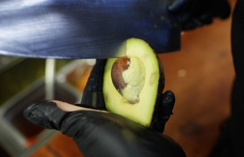 An avocado is cut at the Birrieria Chalio Mexican Restaurant in Fort Worth, Texas, Thursday, Feb. 13, 2025. (AP Photo/LM Otero) TXMO202 TXMO202
