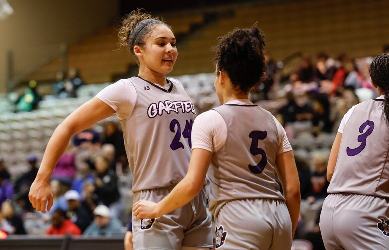Garfield’s Jayda Lewis (24) bumps chests with teammate Lena Most after Most got the bucket and the foul in the first half against Eastside Catholic.  The Garfield High School Bulldog Girls Basketball team played the Eastside Catholic Crusaders in the Metro League Championship game Friday, Feb. 14, 2025 at Royal Brougham Pavillion, on the campus of Seattle Pacific University. 229279