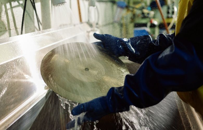 A worker at Quality Record Pressings rinses a master disc to remove any dust or debris from the grooves, in Salina, Kan., in January 2025. Chad Kassem is on a mission – saving listeners “from bad sound” – at the rural factory where he pores over LPs from some of music’s most important artists. (David Robert Elliott/The New York Times)