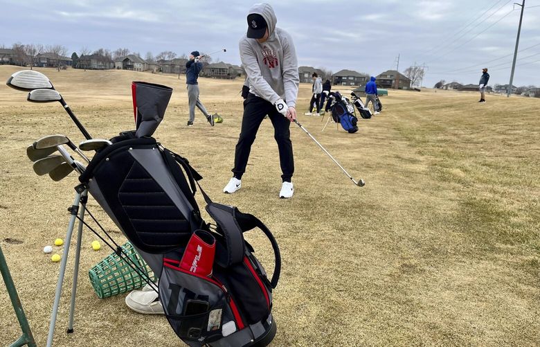 Golfers line up to take some practice shots on the driving range of the Stone Creek Golf Course in Omaha, Neb. on Monday afternoon, March 3, 2025, before hitting the links. (AP Photo/Margery Beck) RPMB501 RPMB501