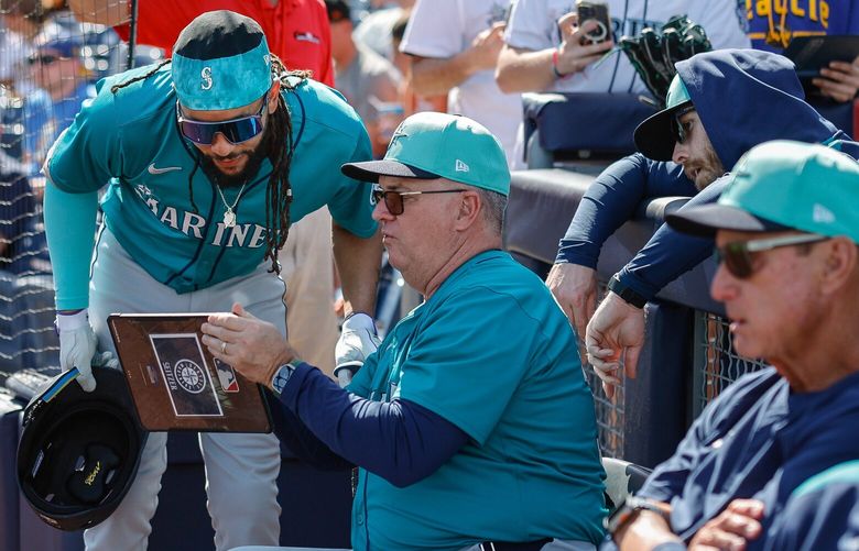 Leadoff hitter J.P. Crawford checks in with hitting coach Kevin Seitzer before heading to the plate in the first inning.  The Seattle Mariners opened Cactus League play with the San Diego Padres Friday, Feb. 21, 2025 at the Peoria Sports Complex, in Peoria, AZ. 229378