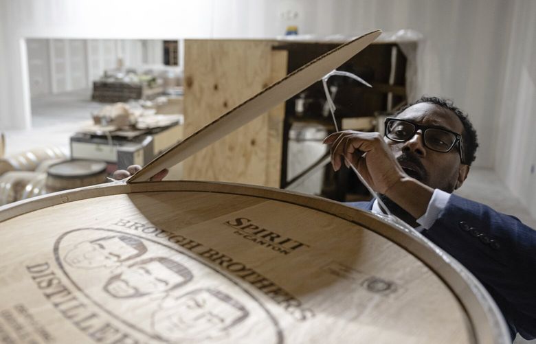 Victor Yarbrough, CEO of Brough Brothers Distillery, removes the cover from an empty barrel of bourbon in the under construction facility in Louisville, Ky., Saturday, March 8, 2025. (AP Photo/Jon Cherry) KYJC302 KYJC302
