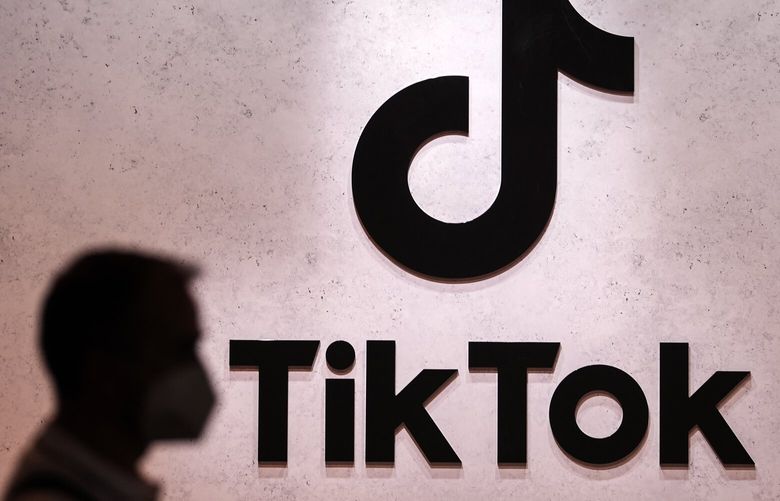 FILE – A visitor passes the TikTok exhibition stands at the Gamescom computer gaming fair in Cologne, Germany, Thursday, Aug. 25, 2022. (AP Photo/Martin Meissner, File) AMB102 AMB102