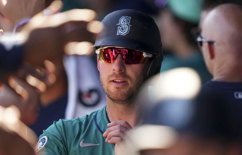 Seattle Mariners’ Mitch Garver is greeted in the dugout after scoring on a two-run double by Tyler Locklear during the second inning against the Arizona Diamondbacks during a spring training baseball game Sunday, Feb. 23, 2025, in Peoria, Ariz. (AP Photo/Lindsey Wasson) AZLW725 AZLW725