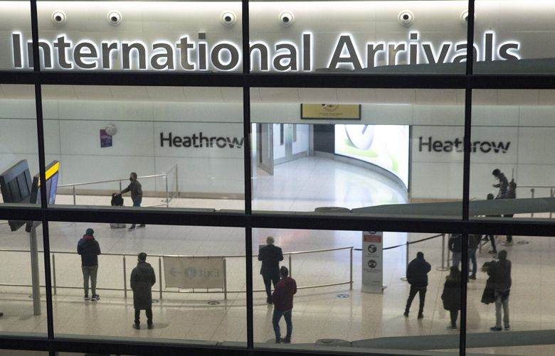 FILE – People in the arrivals area at Heathrow Airport in London, Jan. 26, 2021. The British government says it will grant extensions to several large U.K. airports unable to meet the June 1 deadline to fully install new scanning technology that would have allowed passengers to take two liters (70 ounces) of liquid in their hand luggage — rather than the current paltry 100 milliliters (3.5 ounces). (AP Photo/Matt Dunham, File)