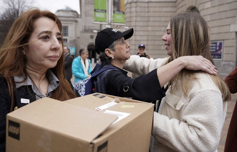 United States Agency for International Development (USAID) workers, embrace each other after retrieving their personal belongings from the USAID’s headquarters in Washington, Thursday, Feb. 27, 2025. (AP Photo/Jose Luis Magana) DCJL121 DCJL121