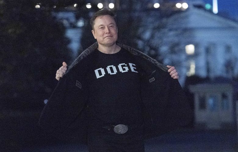 Elon Musk flashes his t-shirt that reads “DOGE” to the media as he walks on South Lawn of the White House, in Washington, Sunday, March 9, 2025. (AP Photo/Jose Luis Magana) DCJL111 DCJL111
