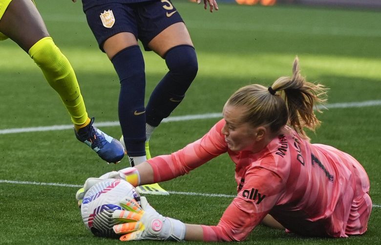 Washington Spirit forward Ouleymata Sarr (11) reaches for the ball as Seattle Reign goalkeeper Claudia Dickey, right, makes a save as defender Phoebe McClernon, left, and defender Lauren Barnes, right, look on during the second half of an NWSL soccer match Sunday, March 17, 2024, in Seattle. The Seattle Reign won 1-0.