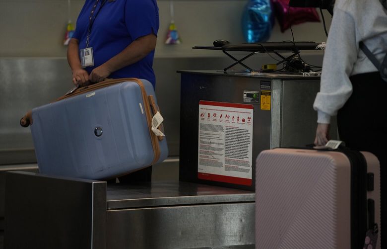A Southwest Airlines traveler checks a bag at Midway International Airport, Tuesday, March 11, 2025, in Chicago. (AP Photo/Erin Hooley) ILEH110 ILEH110