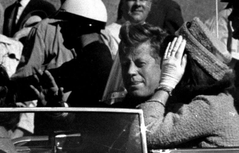 FILE – President John F. Kennedy waves from his car in a motorcade approximately one minute before he was shot, Nov. 22, 1963, in Dallas. Riding with President Kennedy are first lady Jacqueline Kennedy, right, Nellie Connally, second from left, and her husband, Texas Gov. John Connally, far left. (AP Photo/Jim Altgens, File) NY902 NY902