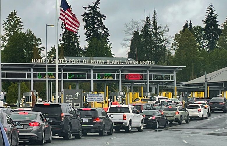 Vehicles line up on the BC Canada side of the border to cross into the United States at Blaine, WA, Sunday, May 15, 2022. Travel restrictions remain lifted due to Covid-19. To get into Canada the ArriveCan app was needed to enter from the U.S. to Canadia. The border officer had questions relating to bird flu. (Ken Lambert/The Seattle Times)