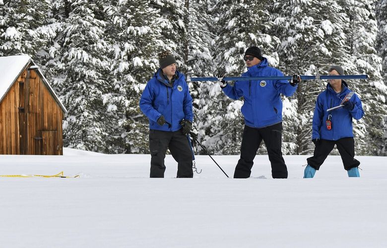 FILE – In this photo provided by the California Department of Water Resources, forecasting chief Sean de Guzman, second from right, and engineers work the measurement phase of the first media snow survey of the season at Phillips Station in the Sierra Nevada Mountains, Calif., Jan. 3, 2023. (Kenneth James/California Department of Water Resources via AP) CLI403 CLI403