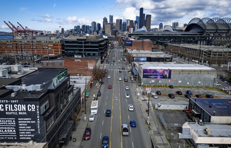 Looking north up First Avenue South, with downtown Seattle in the background, is ground zero for a controversial zoning proposal to expand housing into Sodo, which goes to a city council vote, Tuesday, March 18, 2025. First Avenue South literally and figuratively splits the issue, with the Port of Seattle, in the distance at left being against housing here, and businesses including T-Mobile Park, at right, being for it.