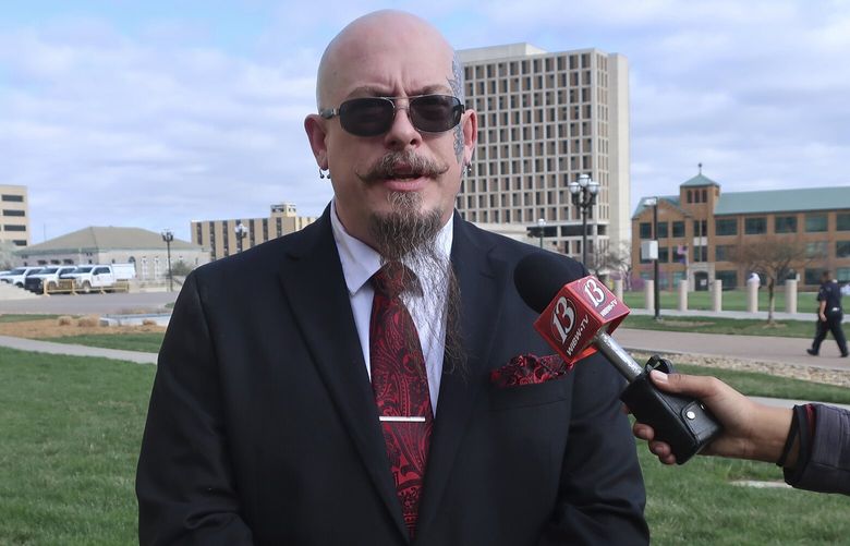 Michael Stewart, the President of the Kansas City-area Satanic Grotto, speaks with reporters as the group’s rally gets started outside the Kansas Statehouse, Friday, March 28, 2025, in Topeka, Kansas.  (AP Photo/John Hanna) RPJH104 RPJH104