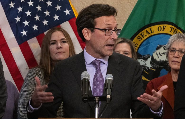 Washington Gov. Bob Ferguson, center, flanked by Washington Attorney General Nick Brown, left, and Washington Treasurer Mike Pellicciotti, right, along with others, holds a news conference, Thursday, Feb. 13, 2025, in Olympia, about federal funding and the state’s response to President Trump’s executive orders.