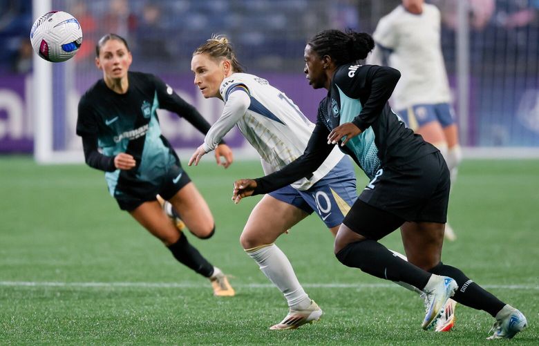 Seattle Reign FC midfielder Jess Fishlock eyes the ball as it bounces away from her and NJ/NY Gotham FC defender Mandy Freeman during the first half Saturday, March 15, 2025 in Seattle. 229494