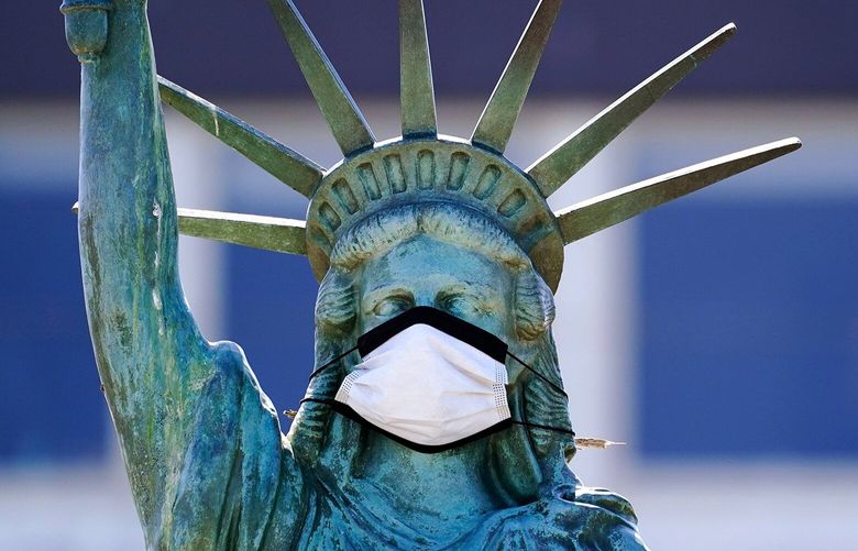 The face on a replica of the Statue of Liberty sports a protective face mask against the coronavirus Wednesday, Aug. 26, 2020, in Seattle. The 1/18th scale replica on Seattle’s Alki Beach was erected in 1952 and recast in 2006.(AP Photo/Elaine Thompson) OTK OTK