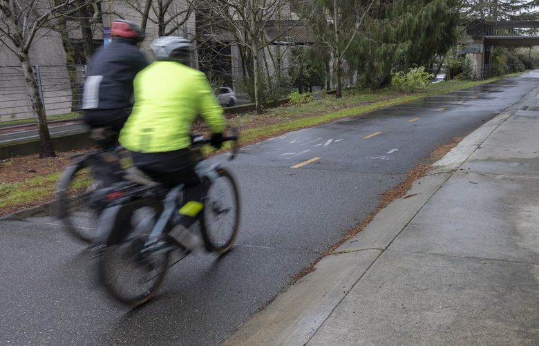 Bicyclists cruise down  the Burke-Gilman Trail at the University of Washington Friday, March 28, 2025.  This section of the trail heads east/southeast from the intersection of 15th Avenue NE and NE Pacific Street toward Husky Stadium. There is a proposal to create a state-spanning network of bikeways called “cycle highways” that would join existing trails with plans for new ones.   This part of the Burke-Gilman is wide, with a two-way bike lane and a pedestrian sidewalk, separated by a gentle curb. It is pointed to as a good example of what a cycle highway would look like. 229642