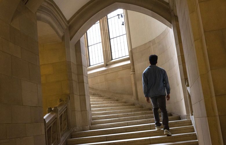 D. J., a participant in a clinical study with Cobenfy, a drug prescribed for schizophrenia, takes the stairs at the Suzzallo Library, a place where he often used to study, on the UW campus Friday, March 7, 2025.  He recently graduated with a degree in computer science from the university. 229325