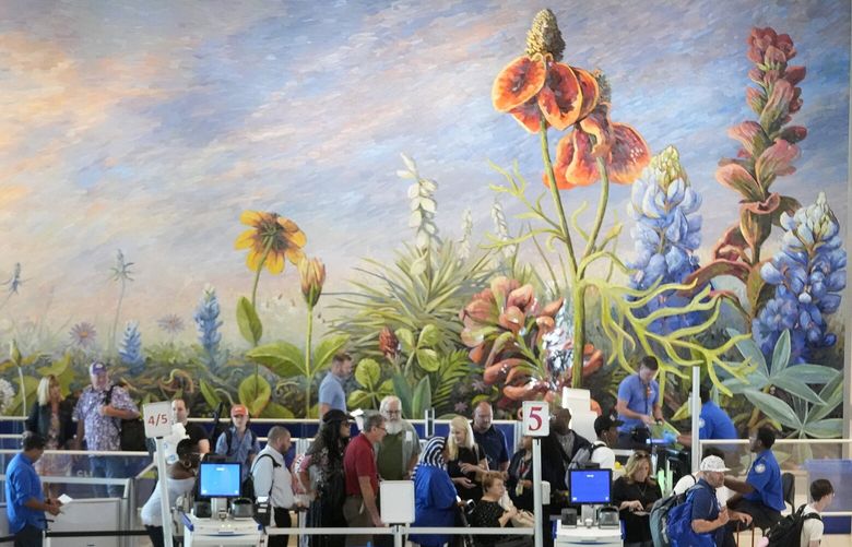 Travelers stand in line to pass through security at Love Field Airport in Dallas, Friday, Aug. 30, 2024.