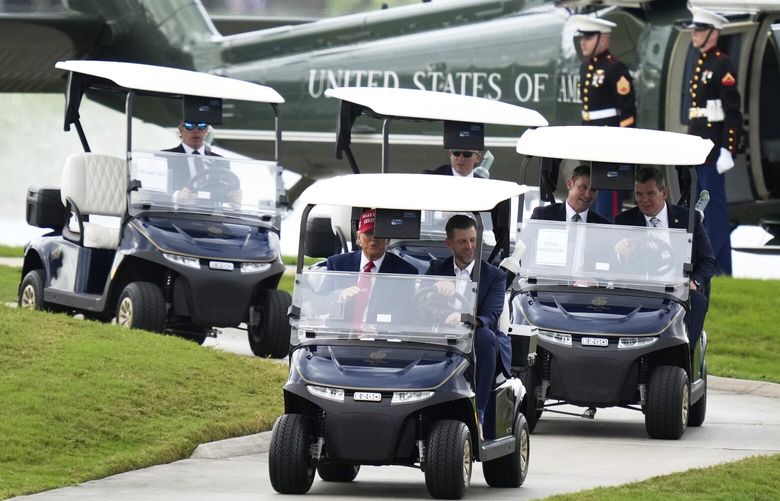 President Donald Trump, driven by his son Eric Trump, arrives at Trump National Doral during the LIV Golf Miami tournament, Thursday, April 3, 2025, in Miami. (AP Photo/Alex Brandon) FLAB213 FLAB213
