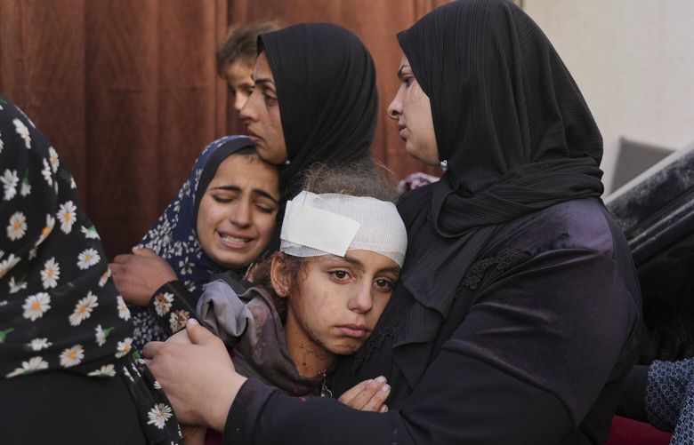 Yamama Jundia, 13, injured in an Israeli airstrike, grieves alongside others over the bodies of their relatives, who were killed in the same strike, at the Baptist Hospital in Gaza City on Thursday, April 3, 2025. (AP Photo/Jehad Alshrafi) XOB107 XOB107