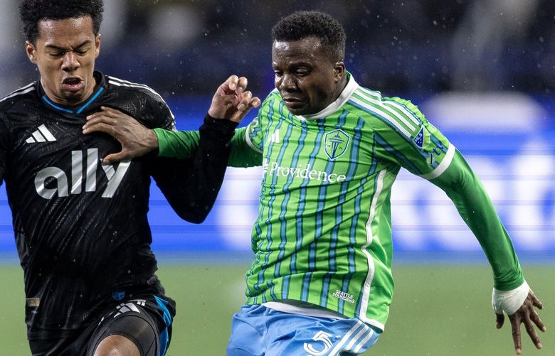 Seattle Sounders defender Nouhou tries to break away from Charlotte FC forward Tyger Smalls during an MLS soccer match on Saturday, Feb. 22, 2025, in Seattle.