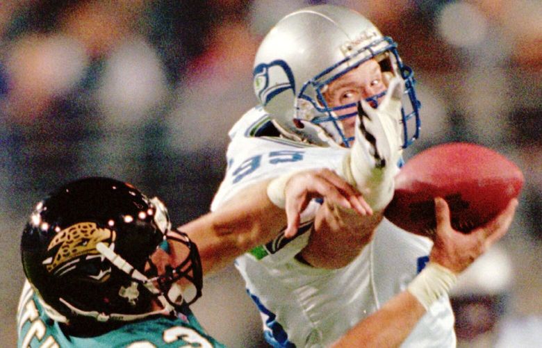 Jaguars’ tight end Pete Mitchell (83) snags a pass in front of the waiting hand of Seahawk’s defender Dean Wells (95) for first down yardage during the first quarter of play Sunday Dec. 15, 1996 in Jacksonville, Fla. (AP Photo/Phil Coale)
