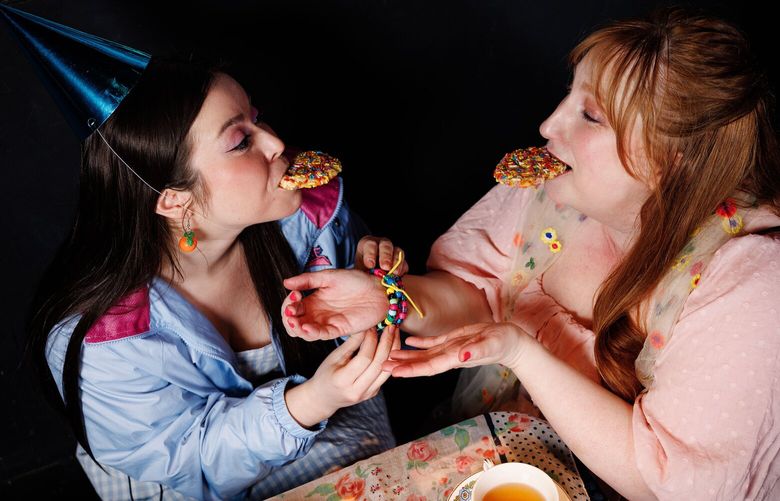 Best friends Emma (Rachel Guyer-Mafune) and Harriet (Emily Huntingford) share tea and cookies in Dacha Theatre’s production of “Emma.”