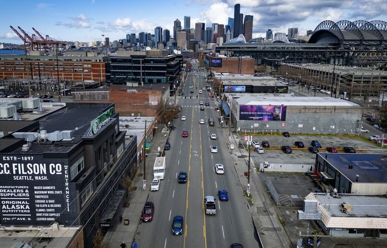 Looking north up First Avenue South, with downtown Seattle in the background, is ground zero for a controversial zoning proposal to expand housing into Sodo, which goes to a city council vote, Tuesday, March 18, 2025. First Avenue South literally and figuratively splits the issue, with the Port of Seattle, in the distance at left being against housing here, and businesses including T-Mobile Park, at right, being for it.