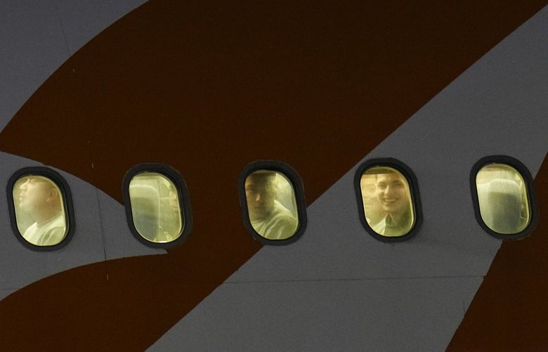 Venezuelan migrants deported from the United States peer through their plane windows as they arrive at the Simon Bolivar International Airport in Maiquetia, Venezuela, March 24, 2025. (AP Photo/Ariana Cubillos) XAB409 XAB409