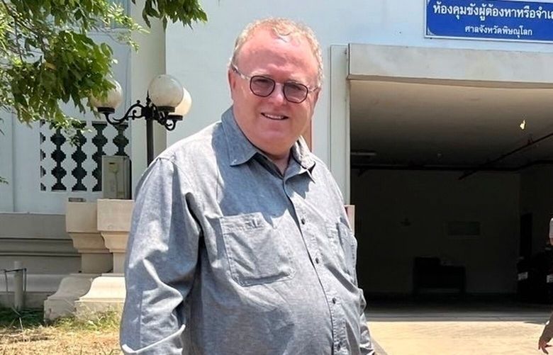 FILE – U.S. political science lecturer Paul Chambers,left, of Thailand’s Naresuan University, stands outside the police station in Phitsanulok, Thailand, where he was arrested on Tuesday, April 8, 2025, on charges of insulting the monarchy. (AP Photo, file) LLT129 LLT129